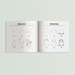 Open art book titled "How to Draw Magical Things" by Paige Tate & Co. featuring colorful illustrations and drawing tips.
