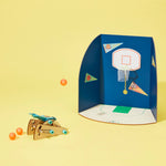 DIY basketball catapult kit from KiwiCo STEAM, showing assembled wooden catapult with colorful basketballs ready for play