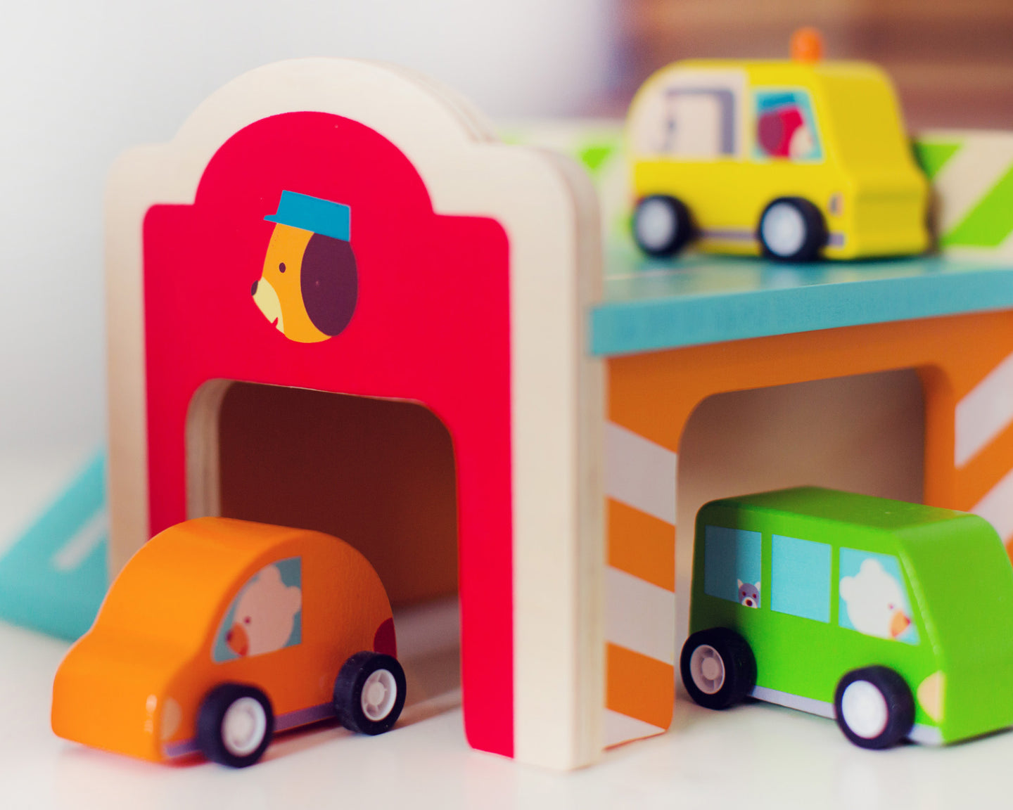 Wooden toddler garage play set with colorful cars and trucks by Djeco, designed for imaginative play and motor skill development.