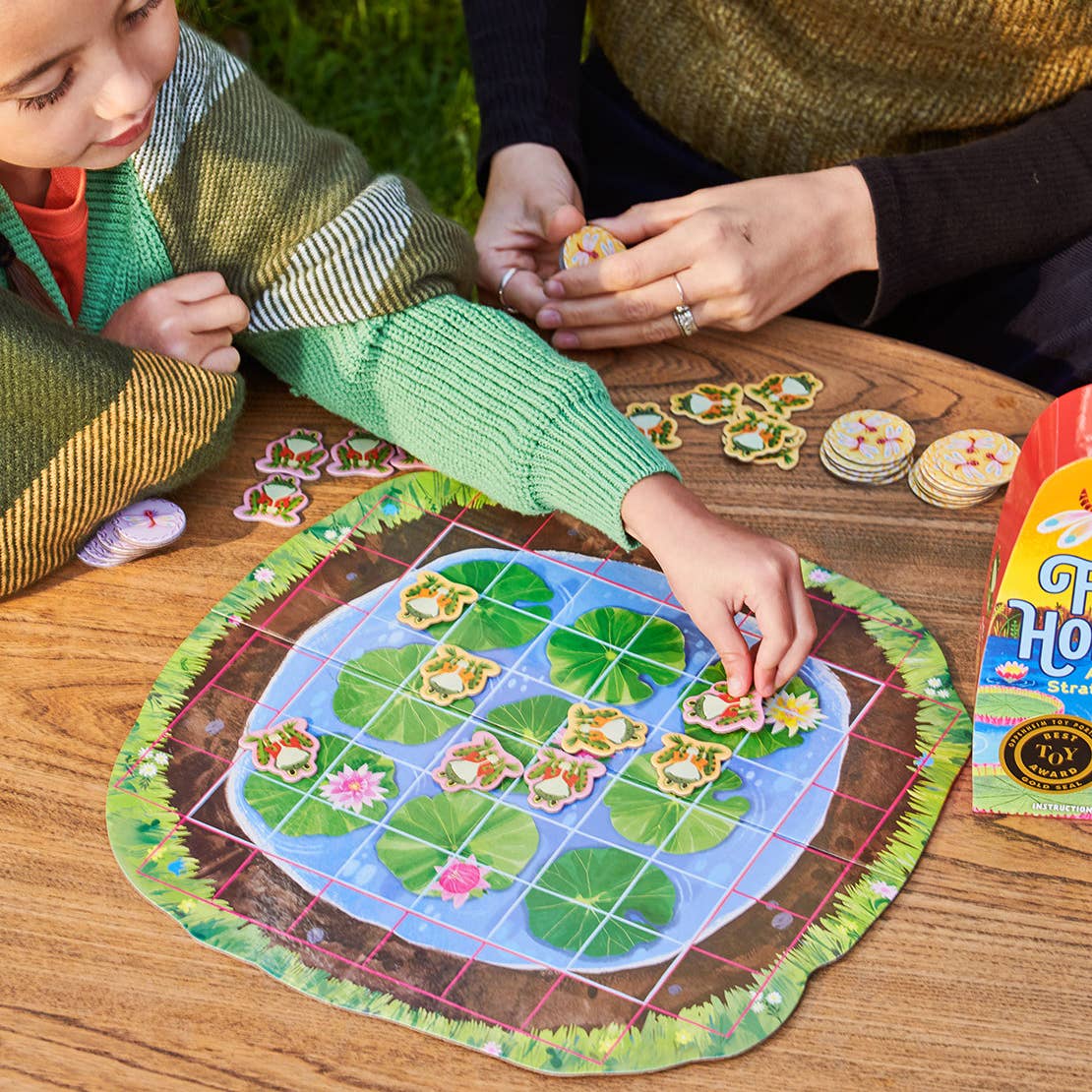 eeBoo Frog Hopkins Board Game featuring colorful frog illustrations and game components on a vibrant playing surface.